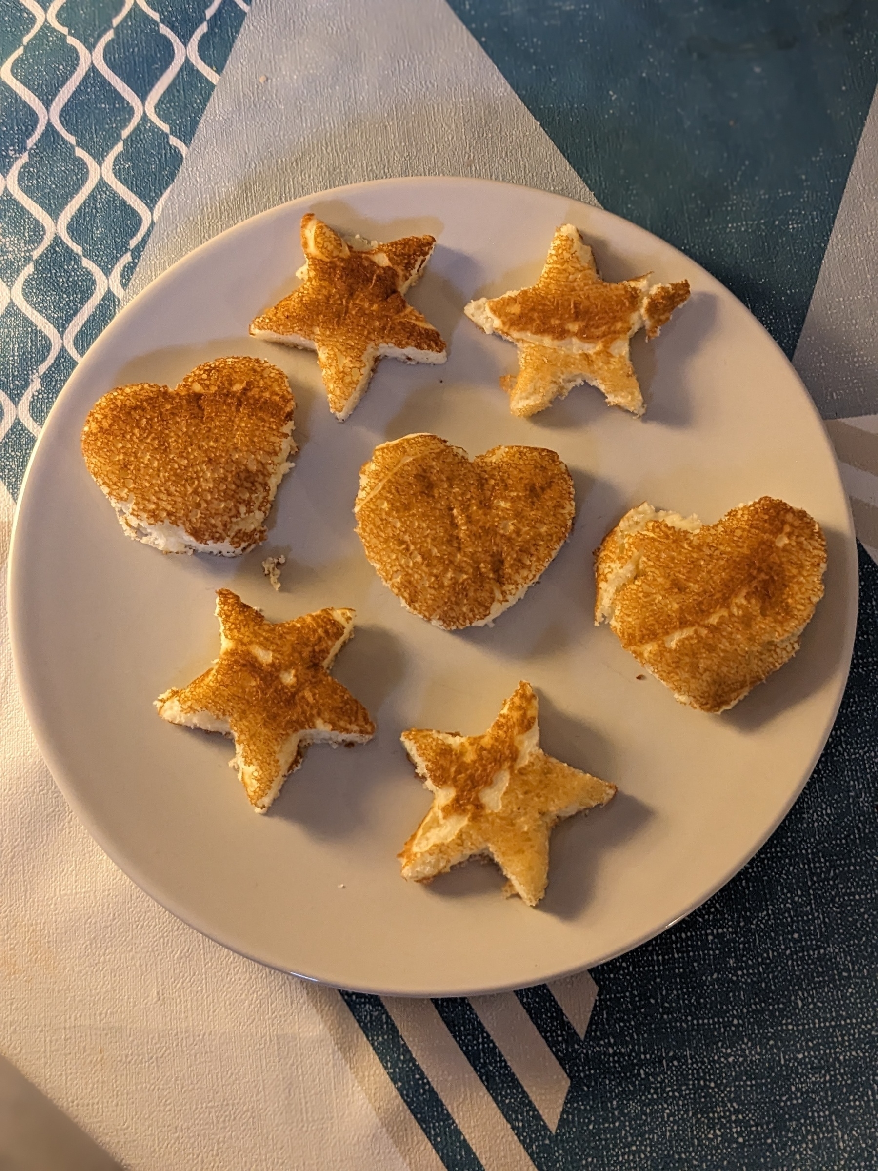 Pancakes cut into star and heart shapes on a plate 